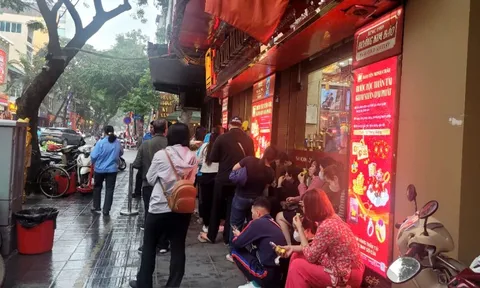Người dân đội mưa xếp hàng chờ mua vàng trước ngày vía Thần Tài